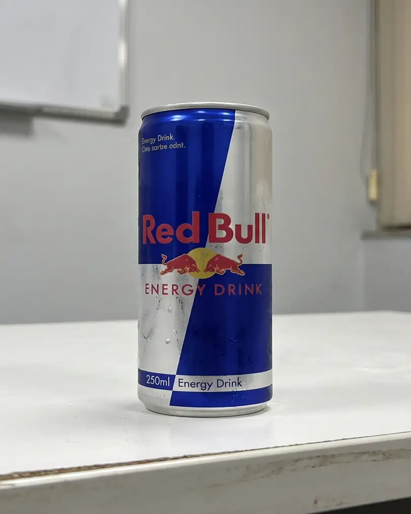Energy drink can on an office desk, shot on a phone