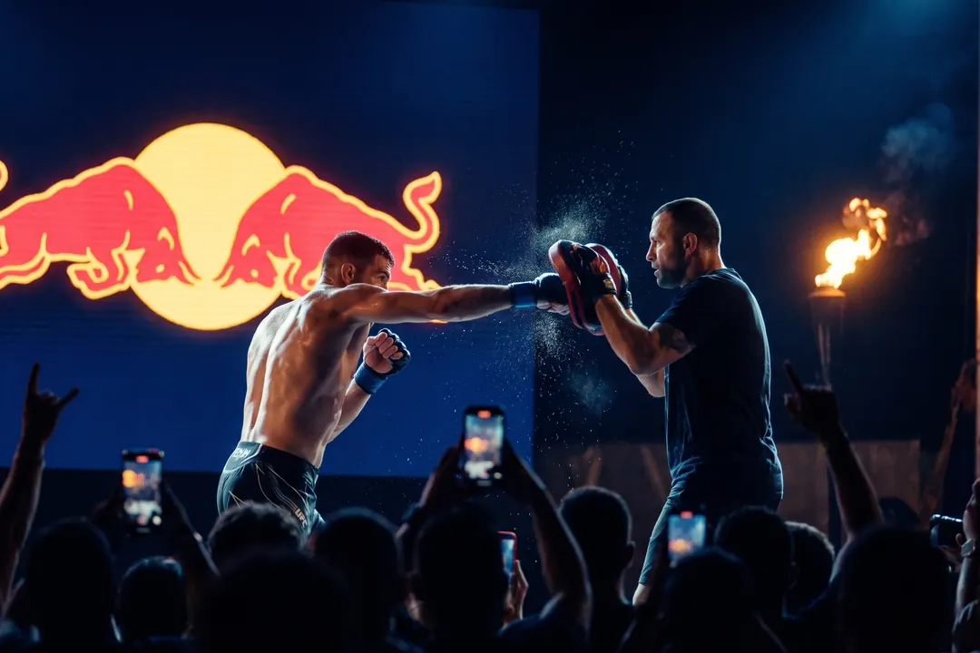 Fighter hitting pads in front of a giant screen and a crowd