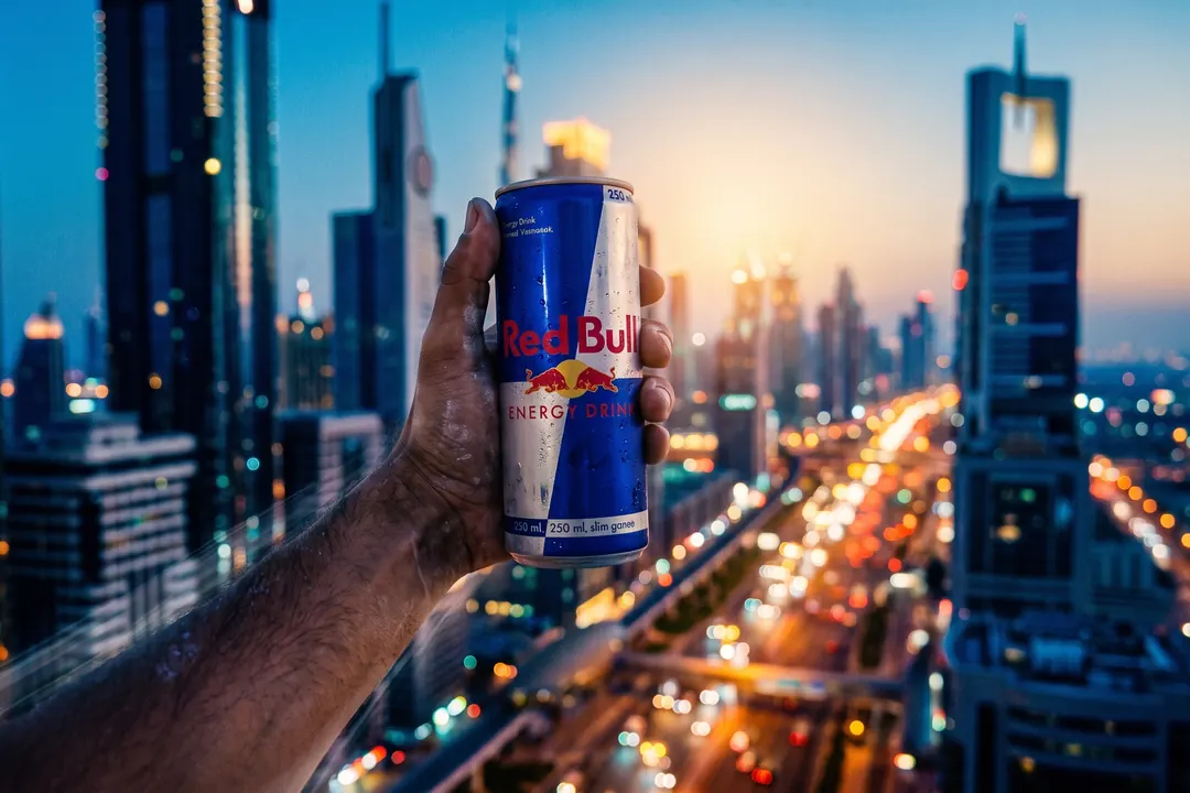 Hand holding the can above a Dubai highway at dusk